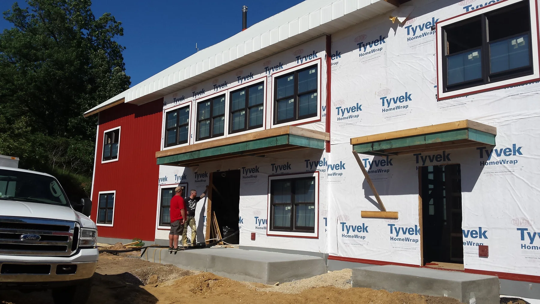 New openings, doors, and housewrap on the front of the barn.