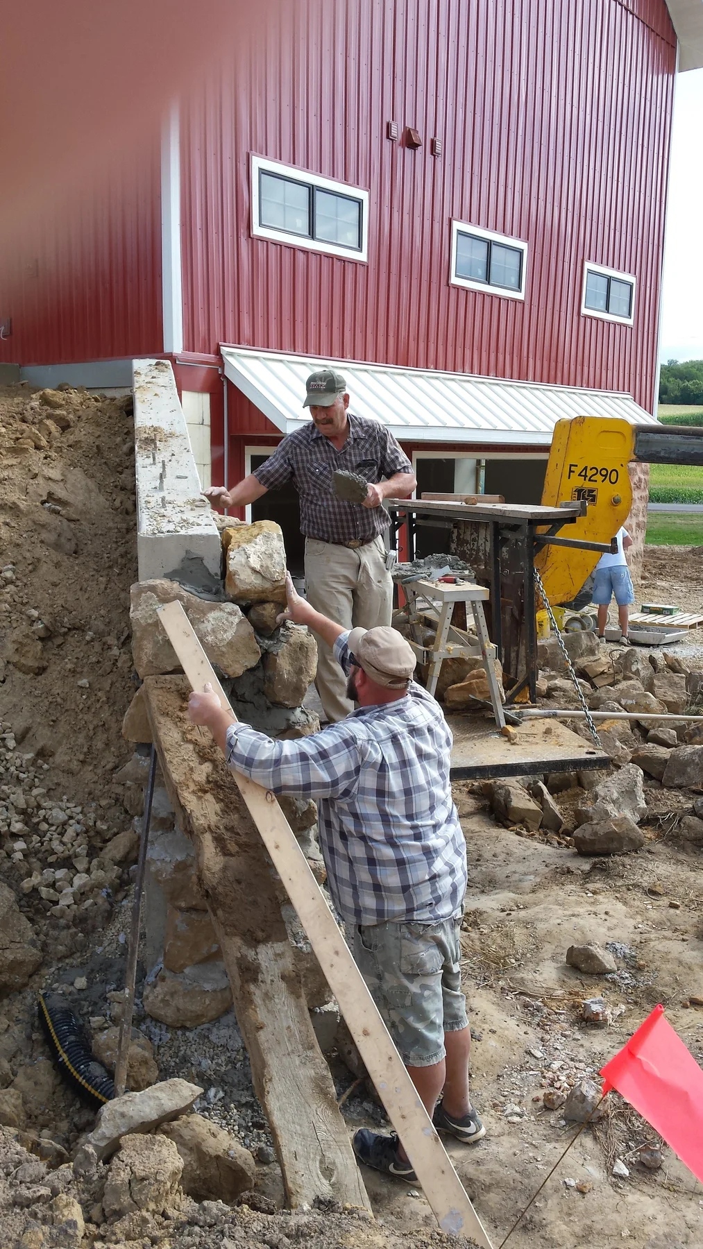 Stonework underway around the barn foundation.