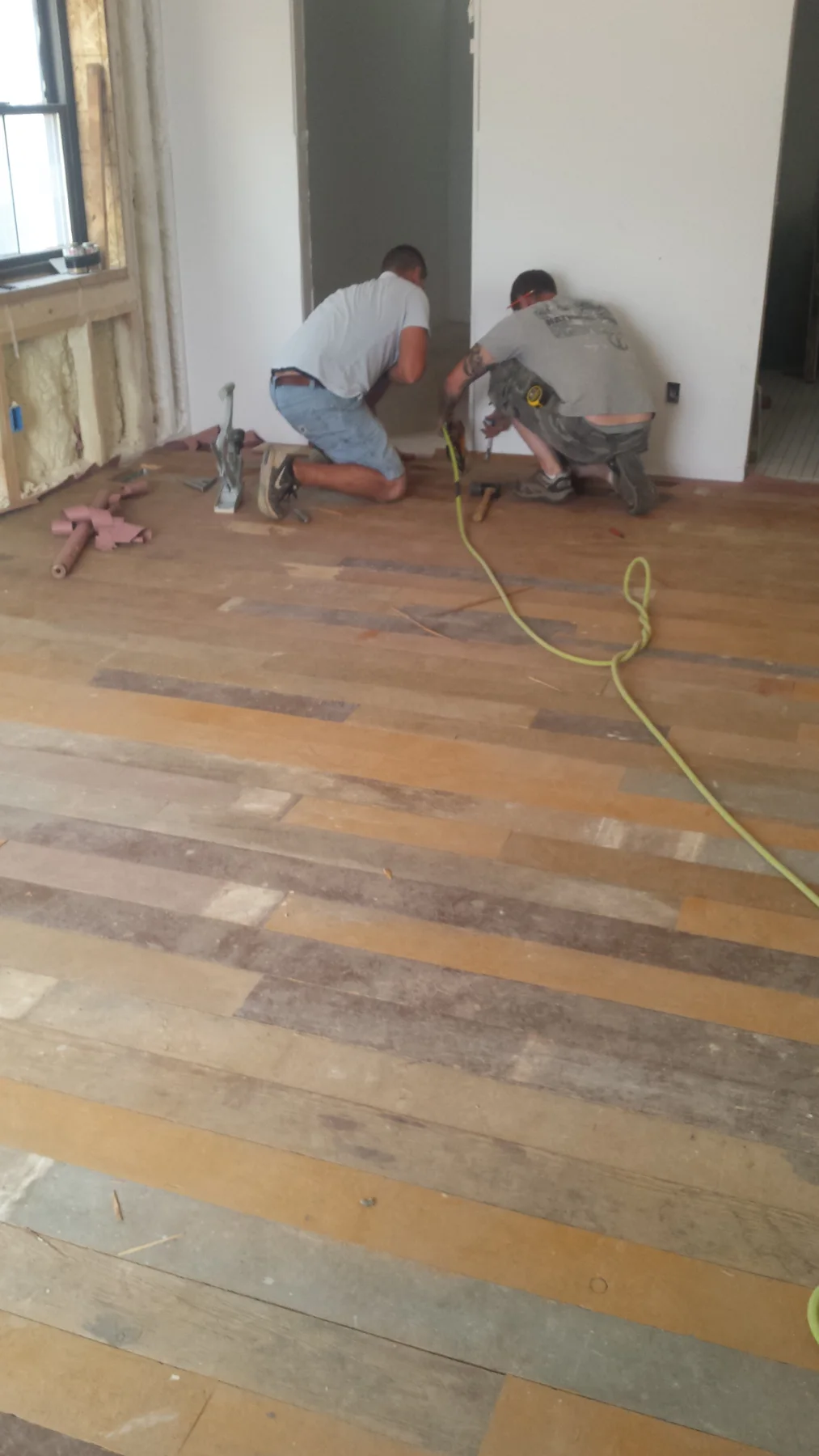 Salvaged wood flooring being laid into the home.